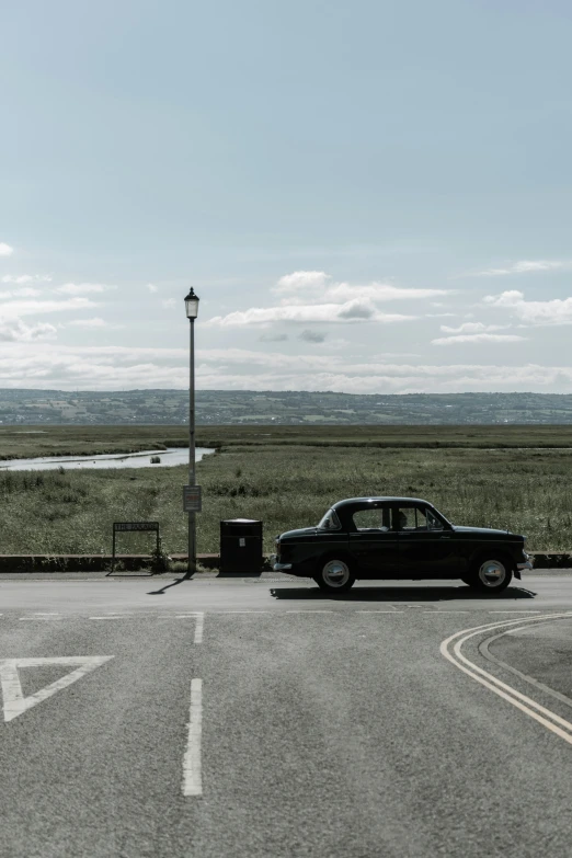 a small vintage car at a roadside entrance