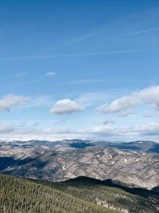 a snow covered hill with a view of the mountains in the distance