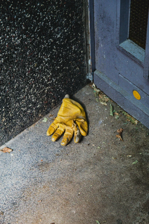 an outside view of a yellow glove with black speckles