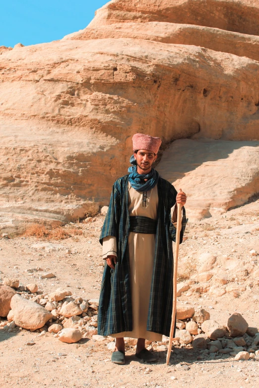 a woman stands in front of an ancient cliff