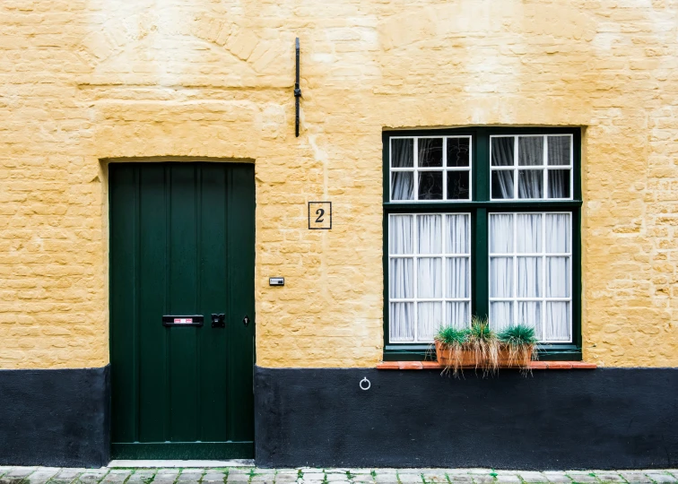 a window and door on a wall of an old building