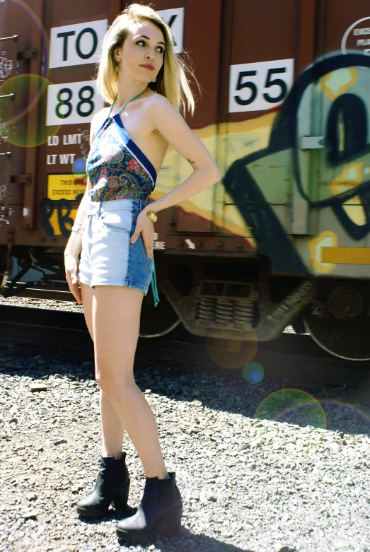 young woman standing in front of train tracks