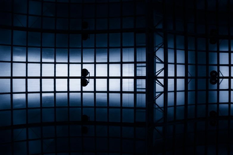 people standing in an dark room through bars