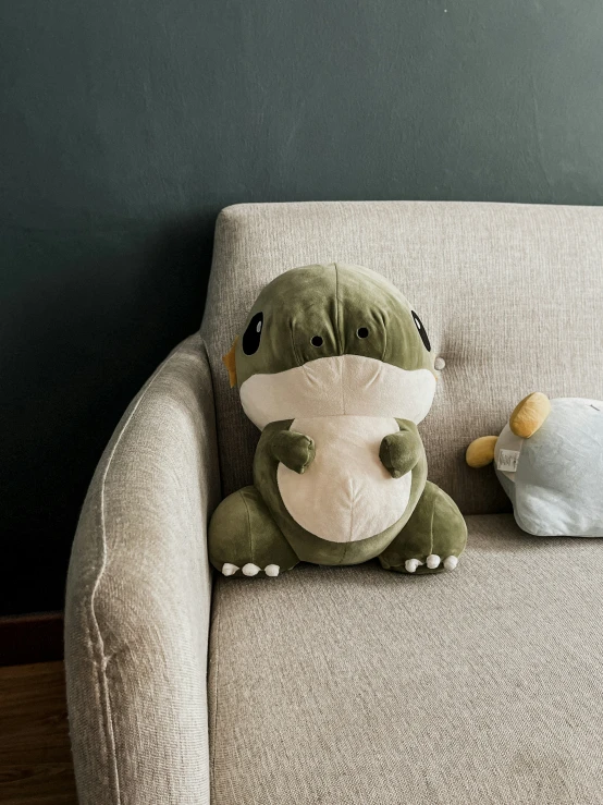 a pillow sitting on top of a chair with a stuffed animal