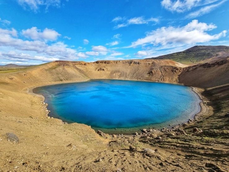 the blue water is surrounded by sand and hills