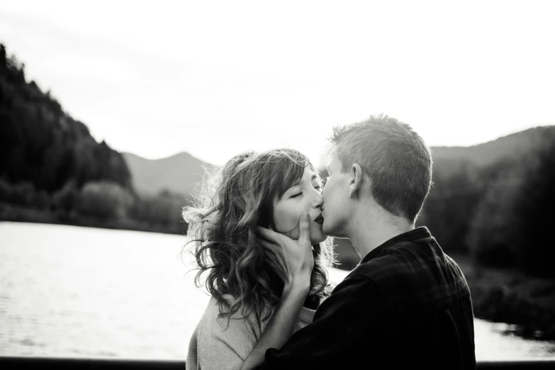 black and white pograph of a man kissing a woman on the cheek