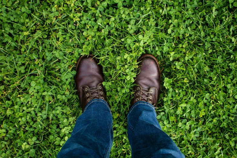 a man is standing on some green grass