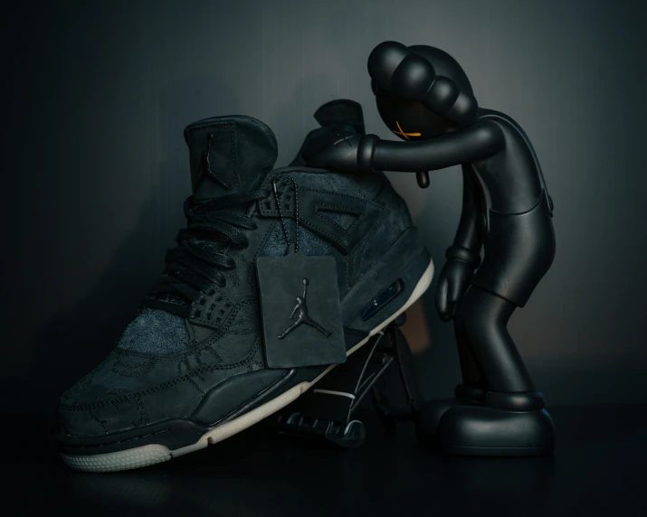 a pair of black sneakers with a statue behind them