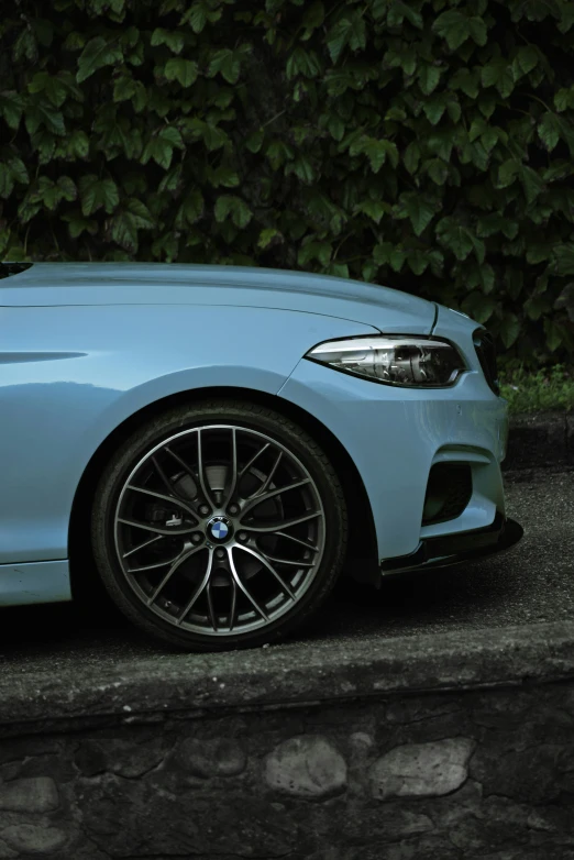 a blue car is parked next to a wall