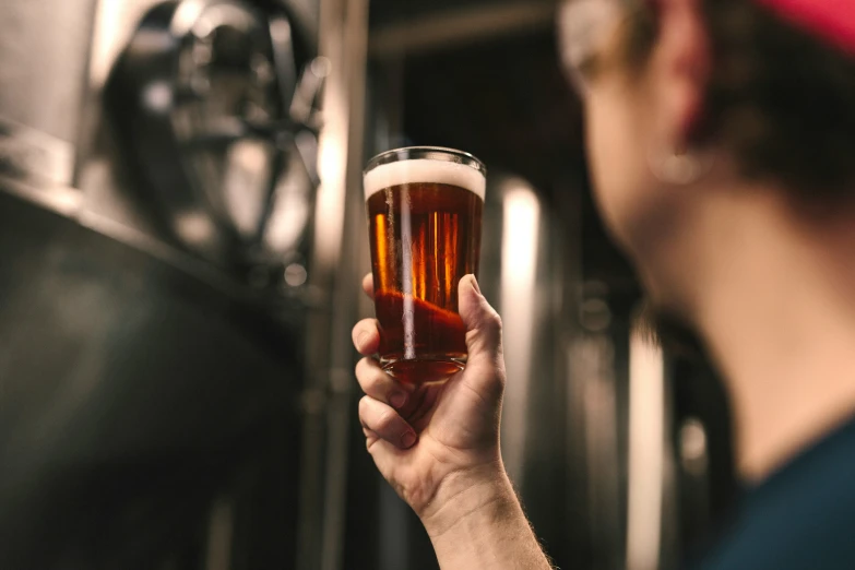 the woman is holding a beer glass by herself