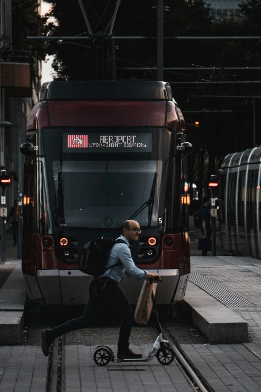 a man hing a wheel chair as he waits on a train