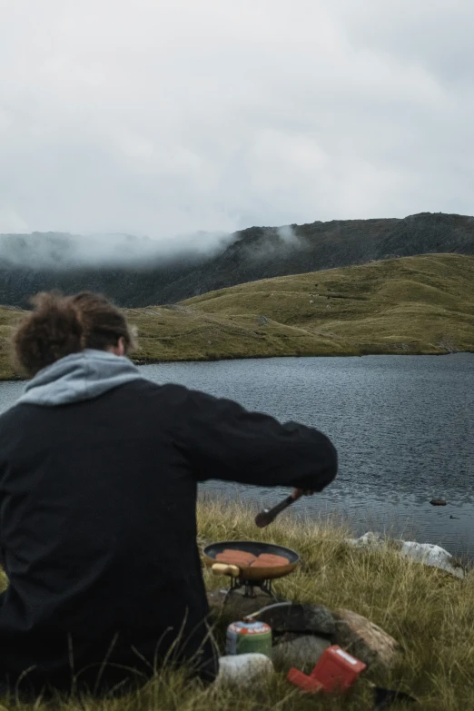 a man sitting in a field with a frisbee