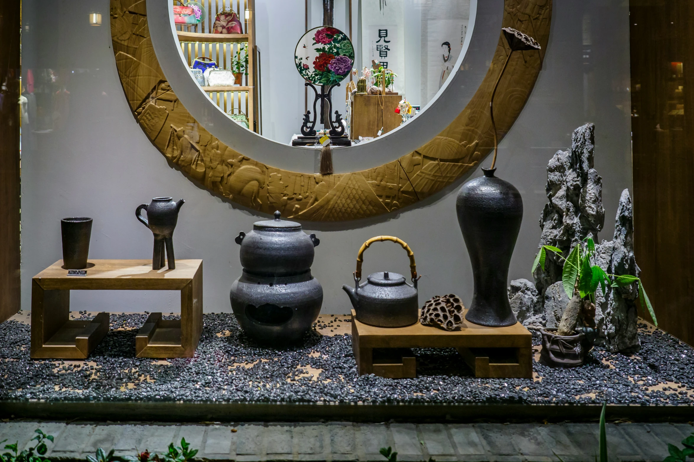 a room with a mirror, table and various pots and vases