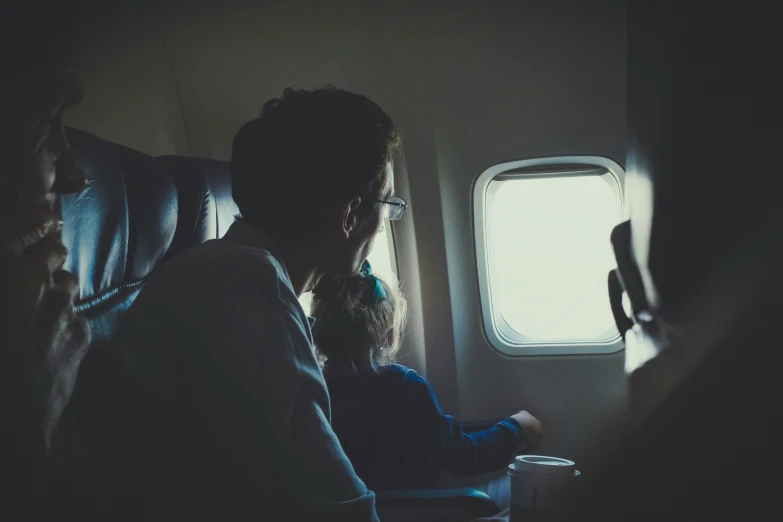 a woman sitting on an airplane with another woman near her