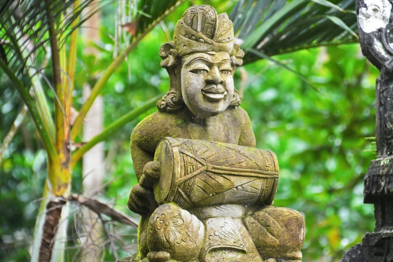 a statue sits on top of a rock in front of some trees