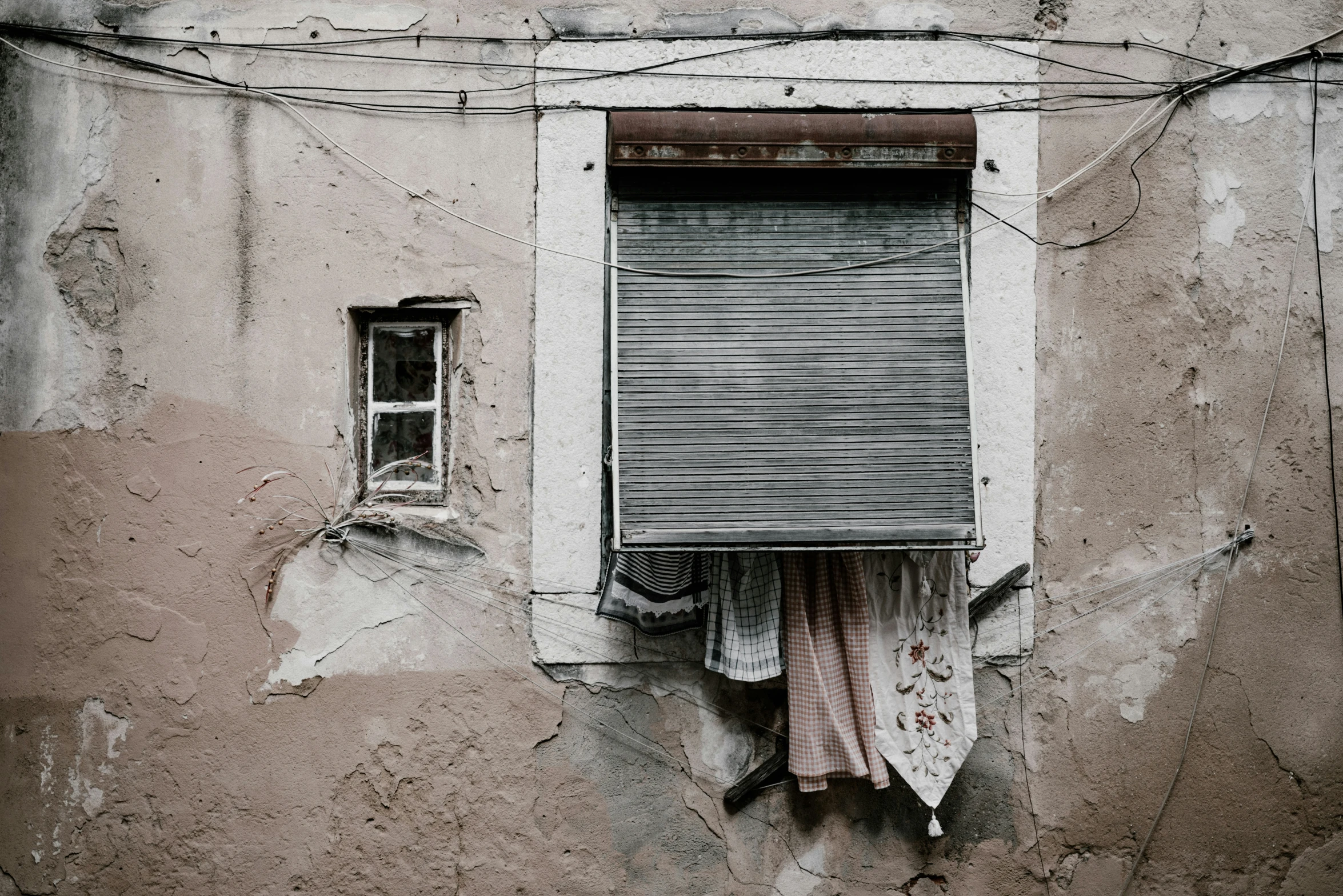 two different kinds of cloth hang from a wire hanging out of an open window