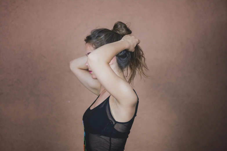 a woman in black tank top holding up her hands