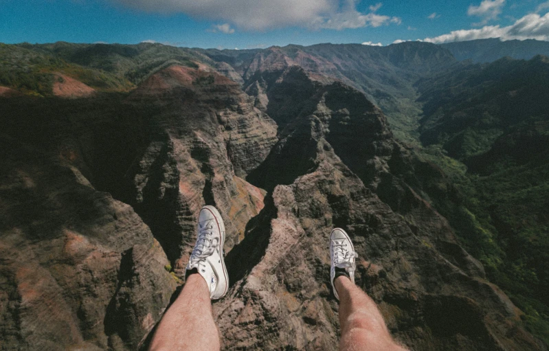 someones feet are pointed upwards, taking a high dive in the mountains