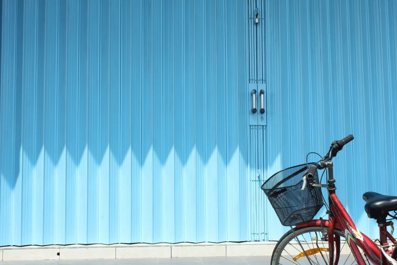 a bike is parked next to a blue wall