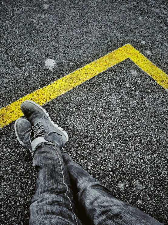 a person standing on a street corner next to a yellow line