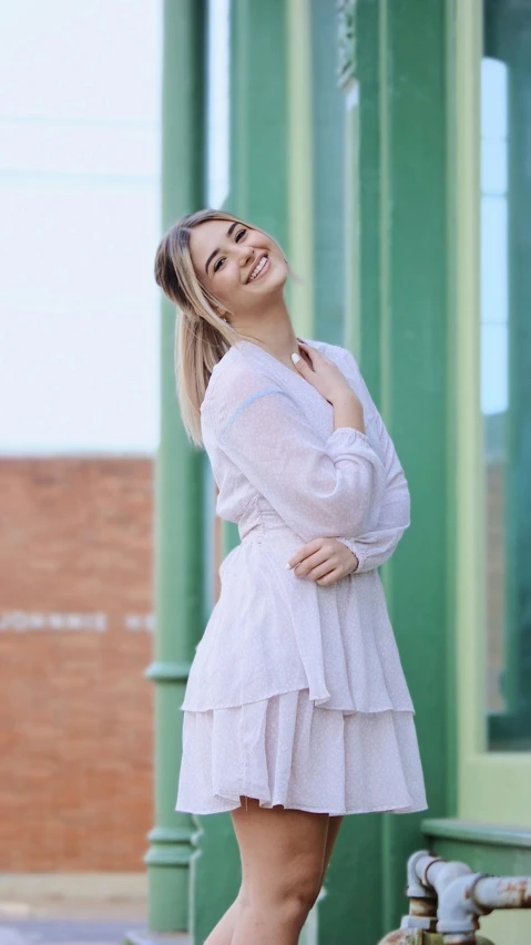 a woman posing for the camera, in a white dress