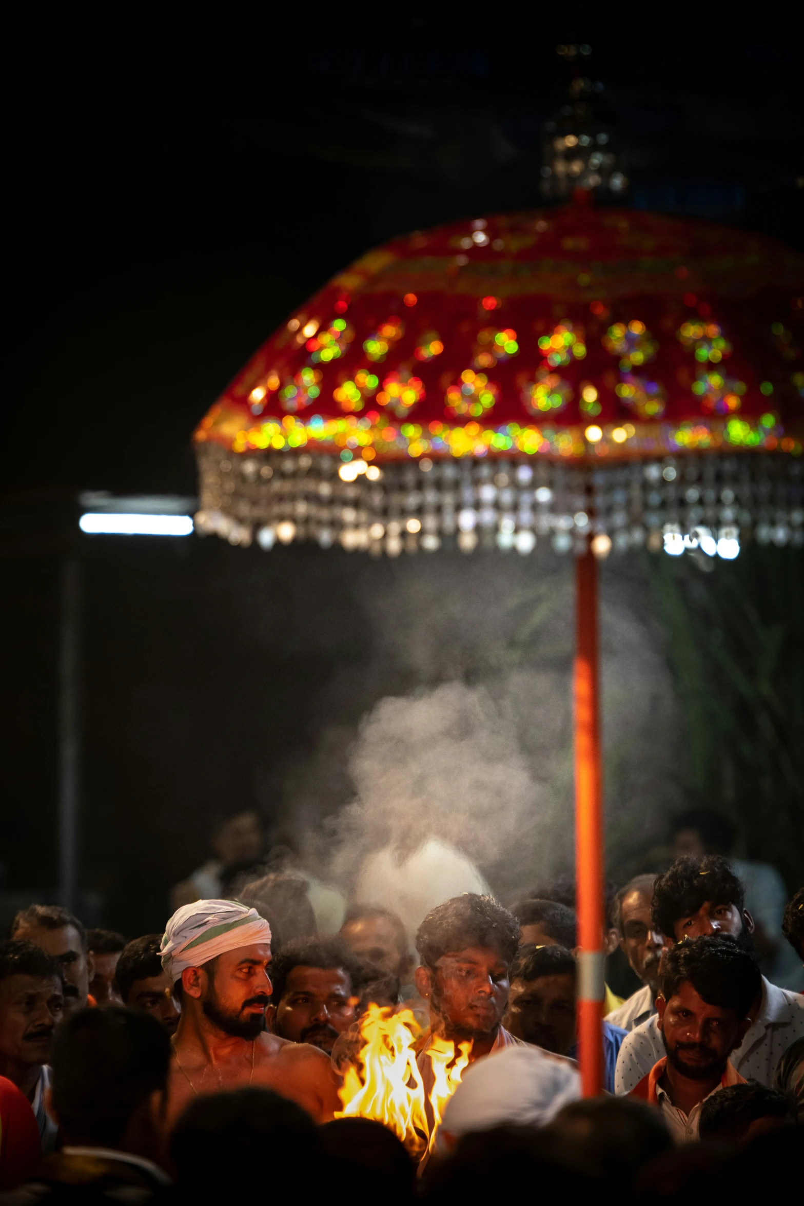 a group of people are gathering around a campfire at night