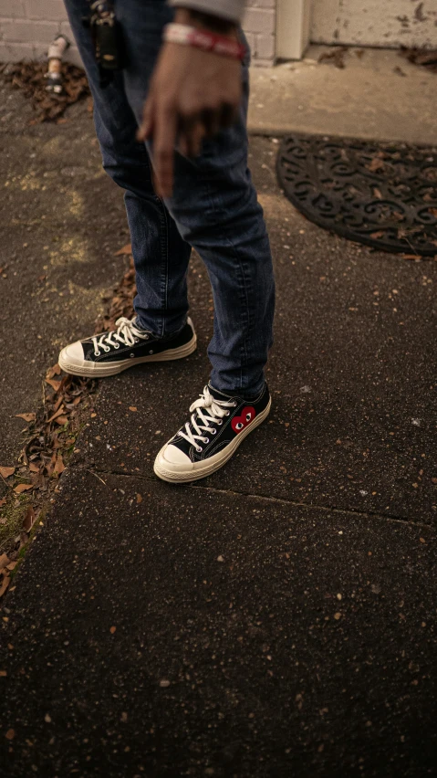 the legs and shoes of someone standing on a sidewalk