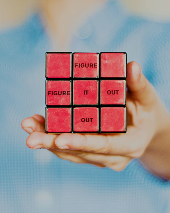 a person holding up two cubes with words inside