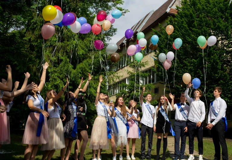 a group of people holding balloons and streamers