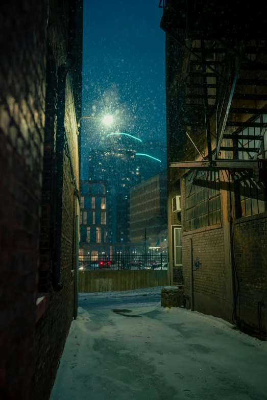 a view from an alley way with snow and buildings