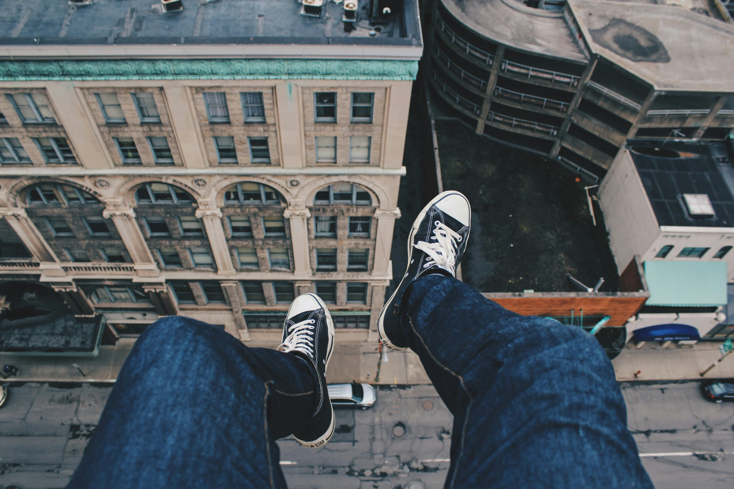 feet with sneakers on near large buildings in city