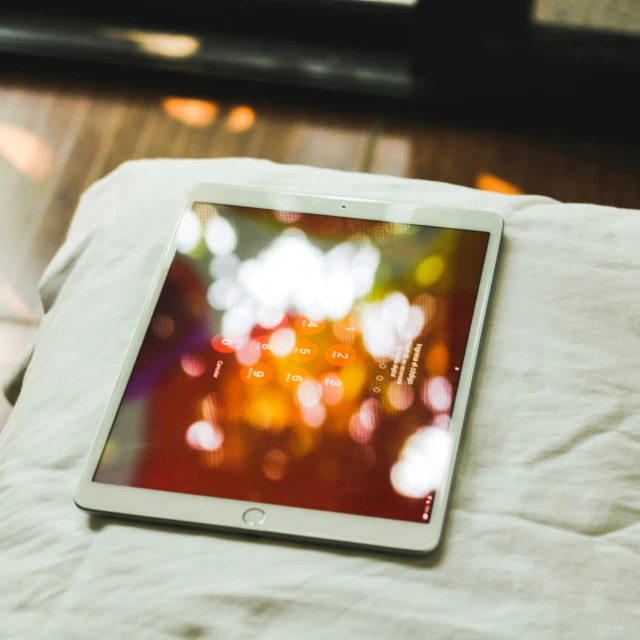 a tablet is on the bed in a room