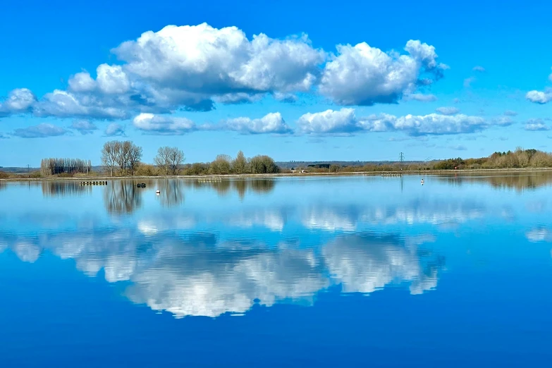 calm lake with a reflection in the water and trees on the side