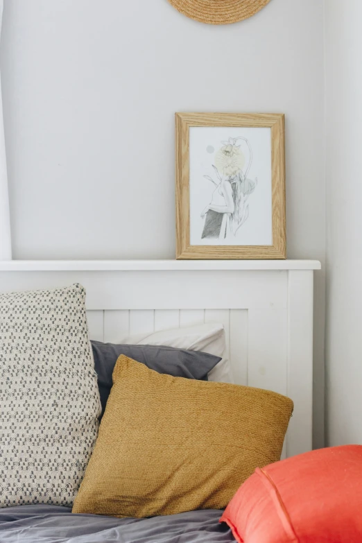 a bed with pillows and paintings on the wall