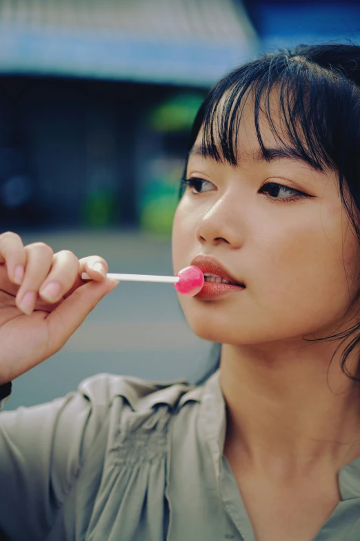 a young woman standing on the side of a street smoking a cigarette