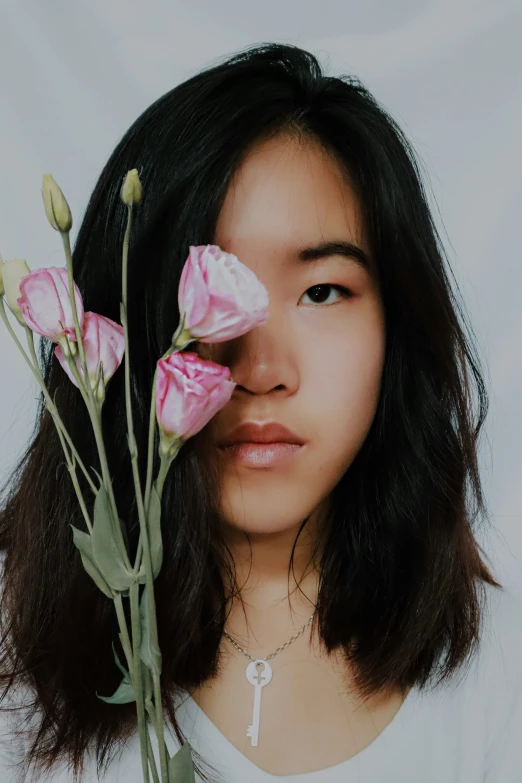 a girl with dark hair holding some flowers