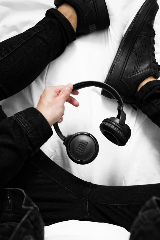 a man wearing headphones sitting in a bed