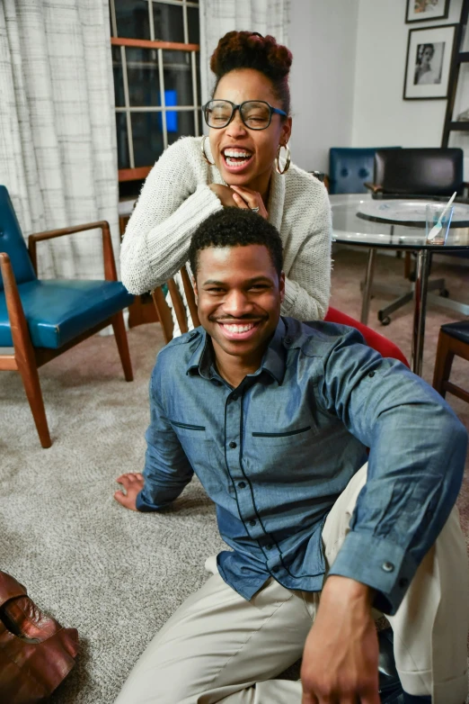 two people in their living room laughing for the camera