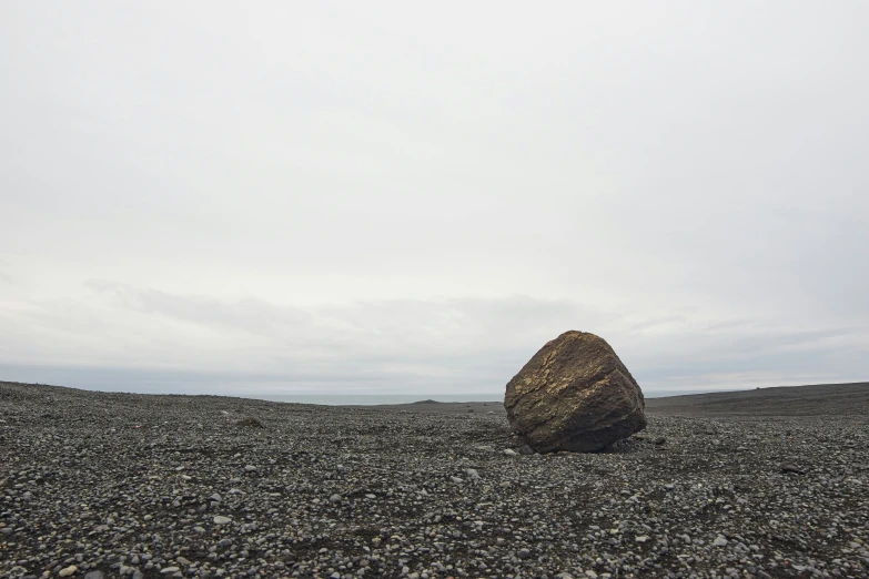 a rock on a sandy beach during the day