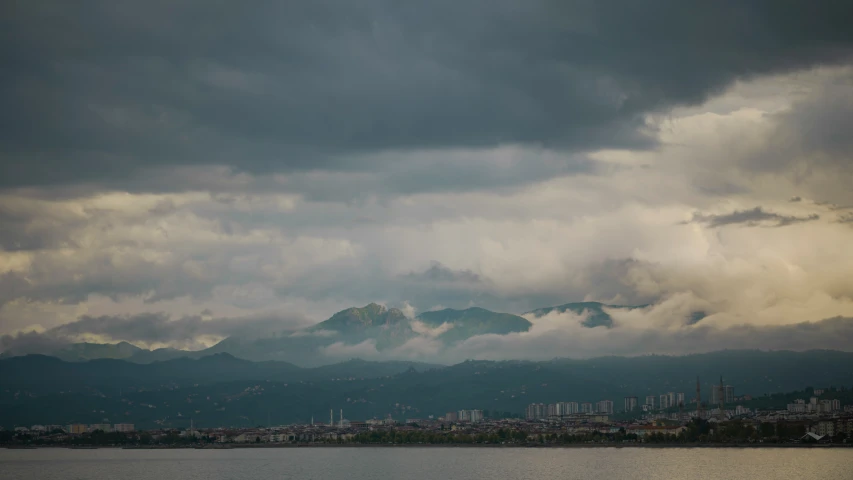 a lake below mountains and some clouds in the sky