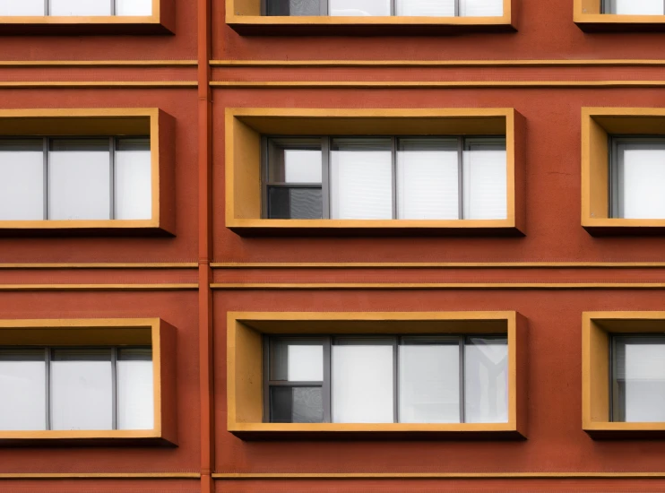 a building with windows and white shutters and yellow border