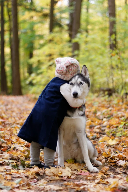 a little girl with her dog in the woods