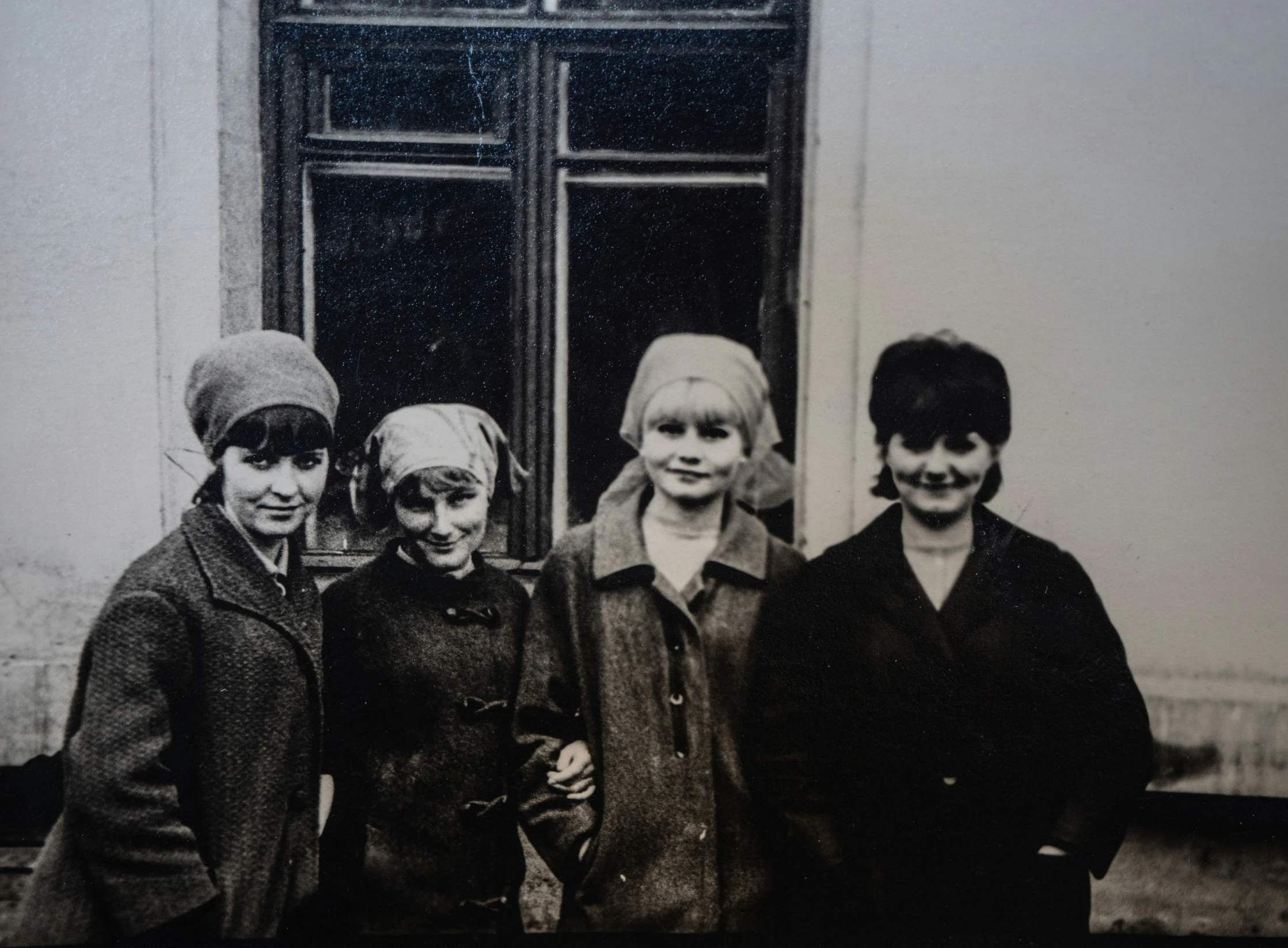 the children are posing in front of a window