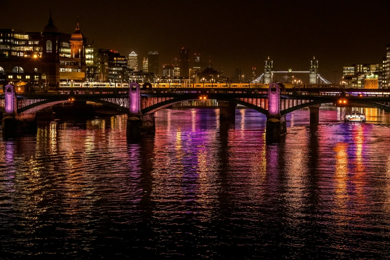 the lights are shining on a bridge and some buildings