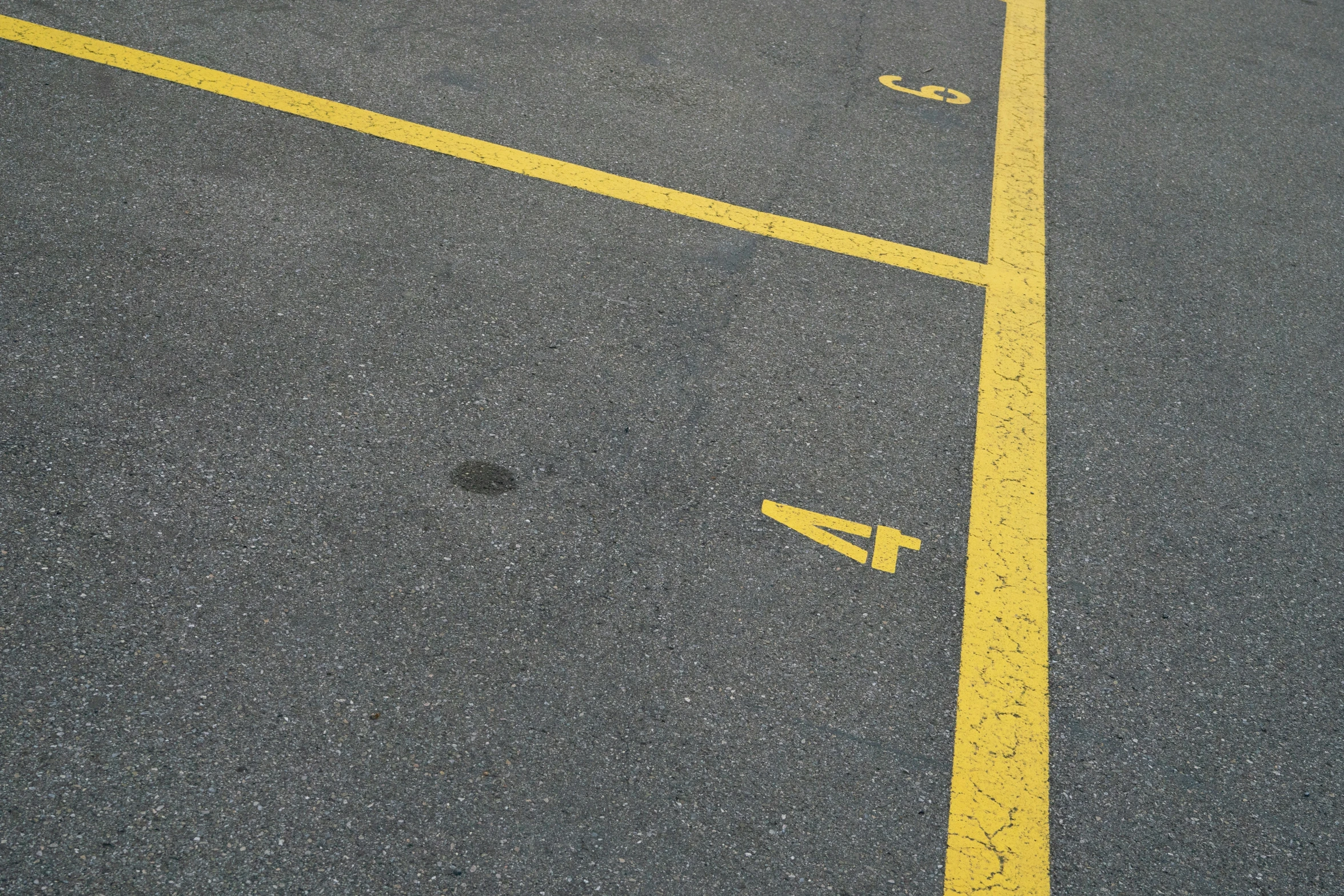 a yellow line on a parking lot is painted with white dots