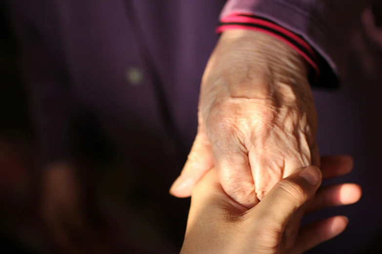 a man and woman hold their hands together