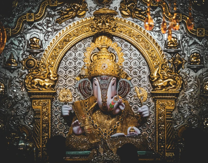 an idol depicting lord gandapa sitting in a gold - painted temple