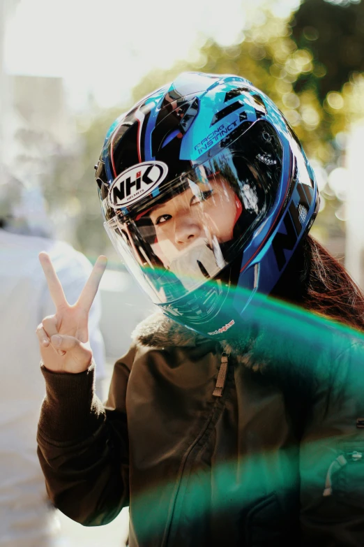 the woman with a helmet is making the peace sign