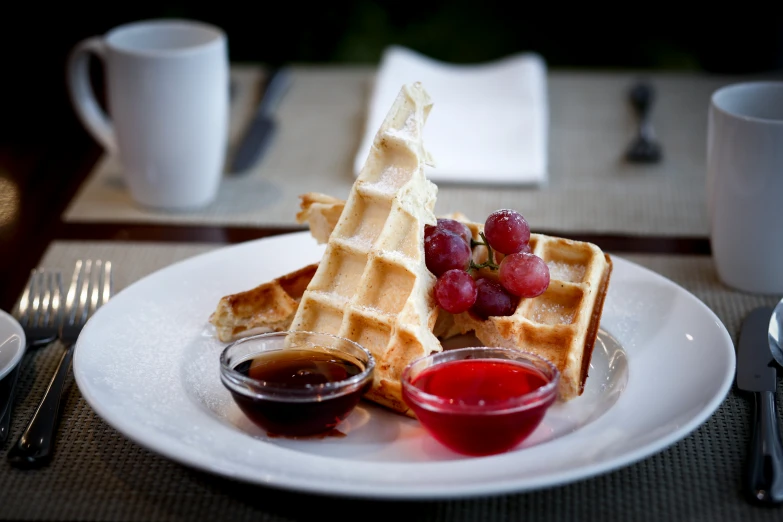 a plate topped with waffles, ketchup, and fruit