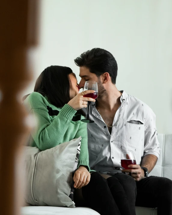 a man kissing the woman while sitting on a couch
